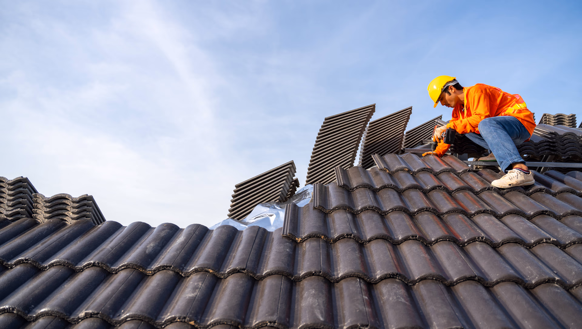 man drilling on a roof