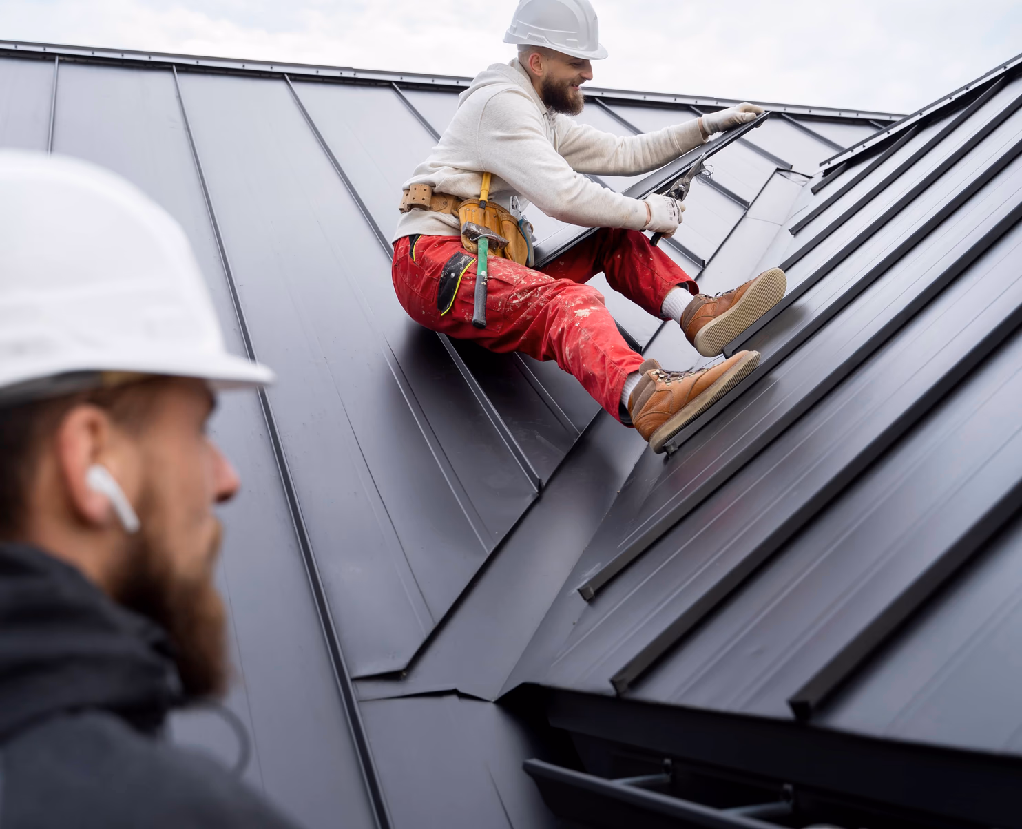 two men working on the roof of a house